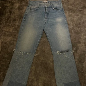 Ljusblå patchwork jeans med råa detaljer - Unika ljusblå jeans från Zara med patchwork-design och råa, slitna detaljer vid knäna. Byxorna har raka ben, och medel midja!