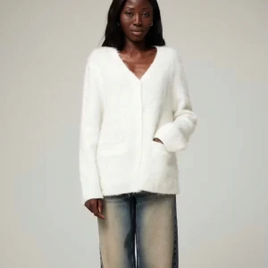 Cardigan - Supermjuk och fluffig vit kofta med v-ringad hals och två fickor framtill. Koftan har lång ärm och en relaxed, lite oversized passform. Endast använd fåtal gånger. Den är i mohair blend, nypris 699kr.