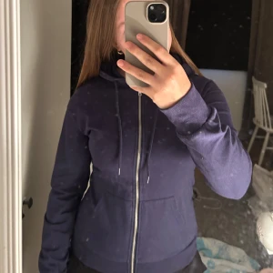 Mörkblå hoodie med dragkedja - Säljer en mörkblå hoodie med dragkedja framtill och snörning i huvan. Från even odd