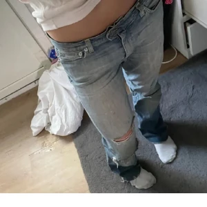 Ljusblå slitna jeans  - Säljer ett par ljusblå jeans med slitningar och hål på ena knät. Bilder från tidigare ägare då de var för korta på mig som är 165🥰 passar om man är 155 typ