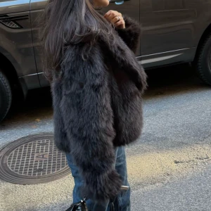 Mörkbrun pälsjacka från Bik Bok - Säljer en pälsjacka från Bik Bok med lång, fluffig fuskpäls och bred krage. Jackan är midjekort och har långa ärmar, perfekt för att ge en cool och lyxig vibe till din outfit. Fodrad insida för extra komfort. Supersnygg till jeans eller klänning.