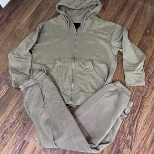 Beige hoodie med dragkedja från 151 - Säljer en beige hoodie från 151 i mjuk bomullsmix. Tröjan har huva, dragkedja framtill och känguruficka. Långärmad och med ribbade muddar. Perfekt för chill dagar eller när du vill vara extra bekväm.