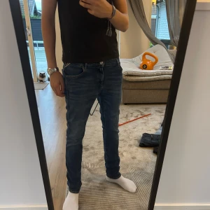 Blå jeans från Replay - Säljer ett par blå skinny jeans från Replay med klassisk femficksdesign och läderpatch bak i midjan. Jeansen har smal passform, normal midja och är tillverkade i stretchigt denim för extra komfort. Perfekta för dig som gillar en tajt look.