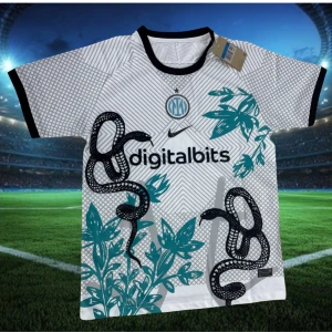 Inter Milan vit matchtröja Nike - Snygg vit Inter Milan fotbollströja från Nike med svart och turkos mönster av ormar och blad. Kortärmad med svart krage och muddar. Digitalbits sponsortryck på bröstet och Inter Milan-emblem. Perfekt för dig som vill sticka ut på planen.