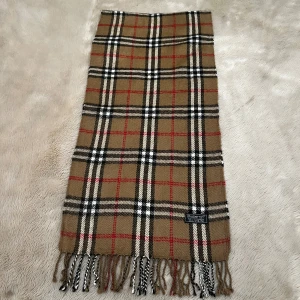 Burberry Halsduk 100% cashmere - Säljer denna fina halsduk från lyxmärket Burberry. Halsduken är i fint skick, knappa täcken på användning. Nypris ligger på mellan 5000 och 6000 kr. Materialet är av 100% cashmere vilket ger en otroligt mjuk känsla. Hör av dig vid minsta fundering eller vid behöv av fler bilder! Priset går självklart att diskutera. 😁