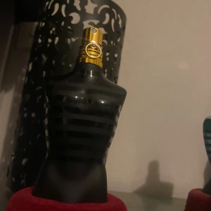 Stilren parfymflaska i svart design - En ikonisk parfymflaska i form av en manlig torso med svart-randig design. Perfekt för dig som vill sticka ut med en klassisk och trendig accessoar på hyllan. Volym och ingredienser syns ej på bilden.