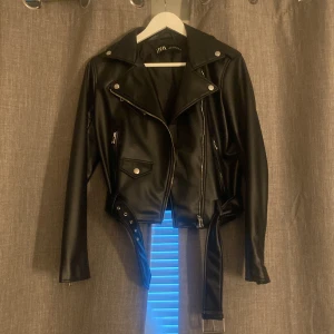 Zara Skinnjacka - En skinnjacka från Zara! Aldrig använd. Jätte bra skick inga fläckar. Storlek M men passar även mig som har Xs/S. Finns främre ficka 