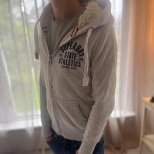 Fodrad Hoodie från Superdry - Superdry hoddie med päls i huvan. Hoddien är i mycket bra skick 8/10. Storleken är S 📏modellen är 177cm och väger 65kg📏 skriv för mer info