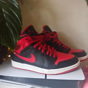 Nike Air Jordan 1 Mid Svart/Röd 43 2022 - Säljer ett par Nike Air Jordan 1 Mid i klassisk svart och röd färg från 2022. Använda endast en gång annars så gott som nya.