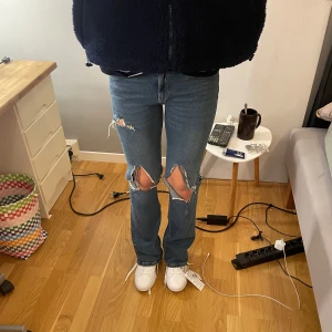 Blå ripped jeans från Perfect Jeans - Snygga blå jeans från Perfect Jeans i storlek 40 med stora slitningar på knäna och ett klassiskt femficksutförande. Modellen har rak passform och normal midja, tillverkade i jeansmaterial. Perfekt för dig som gillar en edgy och avslappnad stil.