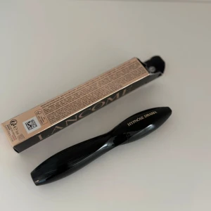 Lancôme Hypnôse Drama Mascara - Lancôme Hypnôse Drama Extreme Volume Mascara i svart, med snyggt böjd borste för maxad volym. Lyxig svart tub med guldtext och elegant roséguldig förpackning. Perfekt för dig som vill ha dramatiska fransar och intensiv blick.