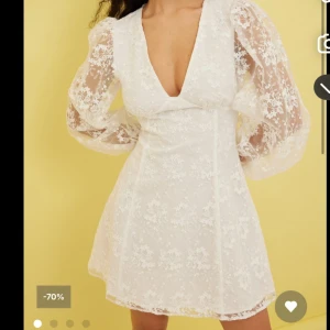 Studentklänning! - Superfin vit kortklänning med v-ringning och transparenta puffärmar i spets.  Lite igensytt vid bröstet (på andra bilden syns det hur de ser ut) och lite färg från smink inuti (ej provat ta bort, men det är inget som syns utanpå som man kan se på bilderna) 