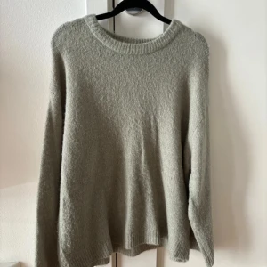 Grön stickad tröja - Mysig beige stickad tröja med rund halsringning och långa ärmar. 