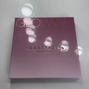 Anastasia Glow Kit  - Glow Kit Sugar från Anastasia Beverly Hills med fyra skimrande highlighters: Marshmallow (ljusgul), Gumdrop (roséguld), Butterscotch (gyllene beige) och Starburst (ljusrosa). Perfekt för att skapa en glowy look. Kommer i en snygg lila palett. Använd få tal gånger 