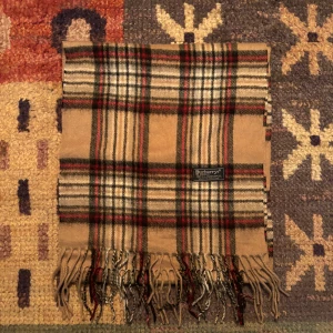 Vintage Burberry Scarf - -Riktigt bra skick. Nypris på dessa ligger på runt 5000kr, vilket gör detta till ett sjukt bra pris! Halsduken är gjord i Lamull, och är perfekt inför hösten och den kommande vintern. Anledningen till att det står ”Burberry’s” och inte ”Burberry” på lappen är eftersom halsduken är från några år tillbaka, innan de bytte namn! Om du har någon fråga är det bara att skriva till mig. /elgnce (5)