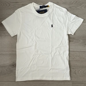 Vit T-shirt med svart logga - Säljer en enkel men snygg vit t-shirt med en logga som skapar en skönhet. Erbjuder denna T-shirt för ett prisvärt erbjudande och postar inom kort. Frågor, Dma👍🏼