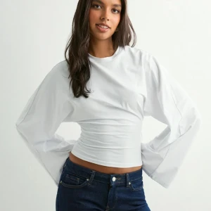 Wide sleeve top från Nelly  - Snygg vit topp med vida långärmar och tajt midja. Säljer då den inte kommer till användning! 