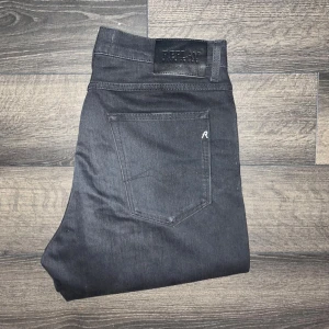 Replay jeans   - Säljer ett par svarta Replay Sandot jeans i tapered fit. Jeansen har fem fickor, klassisk design och snygga detaljer med Replay-logga på bakfickan och läderpatch i midjan. Modellen är relaxed tapered och passar dig som gillar en modern, avslappnad look. Midja 43cm, längd 111cm. JAG SKICKAR INGA FLER BILDER PÅ NÄR JAG BÄR JEANSEN:) s2 