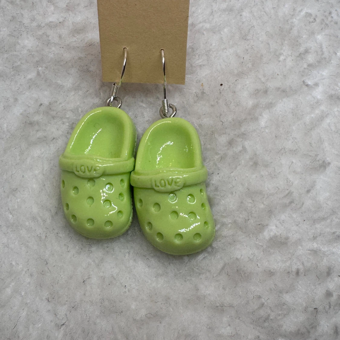 Gröna crocs-örhängen med texten LOVE