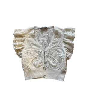 Beige stickad blus med volangärmar - ZARA - Supersöt beige stickad blus med v-ringning, knappar framtill och puffiga volangärmar i spets. Croppad modell med fina broderade detaljer och romantisk känsla. Perfekt för dig som gillar en feminin och trendig look. 