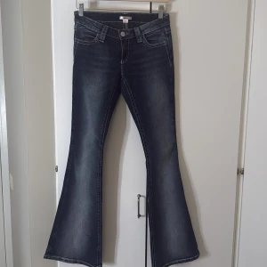 Mörkblå bootcut jeans med broderi - Snygga mörkblå bootcut jeans med markerade sömmar och broderade bakfickor. Jeansen har klassisk femficksdesign och är tillverkade i stretchigt denim för en bekväm passform. Perfekta för dig som vill ha en cool och unik look. Gina tricot 14+