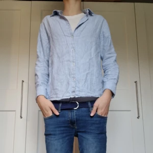 Blårandig skjorta i bomull, strl 158 - Snygg blårandig skjorta med klassisk krage och knappar framtill. Skjortan är tillverkad i mjuk bomull och har lång ärm. Passformen är normal och tyget har tunna vita och blå ränder som ger en fräsch look. Perfekt för dig som gillar stilrena och enkla plagg. Modellen på bilden är 171 cm och plagget passar för dig som är mellan 155 till 165 cm