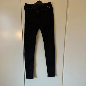 Svarta Replay jeans  - Snygga svarta jeans från Replay med klassisk femficksdesign. Jeansen har smal passform och normal midja, tillverkade i stretchigt jeanstyg för en bekväm känsla. Perfekta för dig som gillar stilrena jeans.