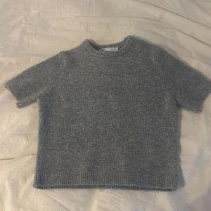 Grå stickad tröja från Zara - Mysig grå stickad kortärmad tröjafrån Zara i storlek S. Tröjan har korta ärmar med en rund hals. Köptes för cirka 330 kr. Har haft i ungefär 1,5 år men använder inte den 