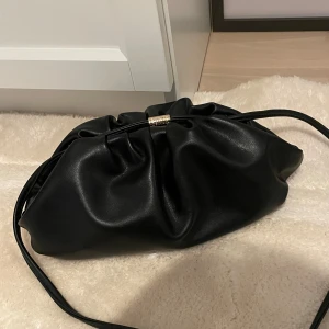Dumplingbag från Bow19 - Snygg svart dumplingväsla från Bow19 med mjukt skinnliknande material och coolt rynkad design. I ny skick, nypris 600kr