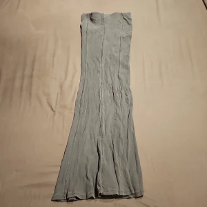 Grå ribbad kjol från H&M - ❗️Skriv innan köp❗️Säljer en lång, ribbad klänning från Divided by H&M i grå färg. Klänningen har en figurnära passform och markerade sömmar för extra design. På mig passar den som en midi kjol. Har används ett fåtal ggr.