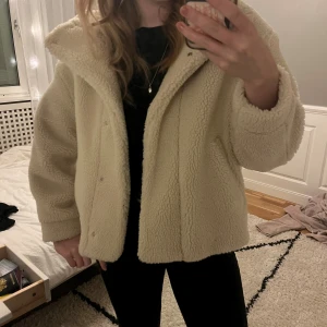 Beige teddyjacka från Zara - Säljer en fluffig och oversized teddyjacka från Zara i beige färg. Jackan har krage, tryckknappar framtill och två sidofickor. Perfekt för dig som gillar mysiga och trendiga jackor med chill vibe. Passar dig som vill ha en varm och cool look.