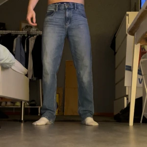 Jeans Lee West - Säljer ett par ljusblå lee jeans med klassisk rak passform och normal midja. Jeansen har fem fickor och stängs med dragkedja och knapp. Perfekta för en avslappnad och stilren look. Storlek:31:32