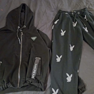 Playboy x Missguided svarta mjukisbyxor - Svarta mjukisbyxor från Playboy x Missguided med vita playboy-kaniner tryckta över hela byxorna. Byxorna har resår och snörning i midjan samt muddar vid bensluten. Perfekta för en chill och trendig look.