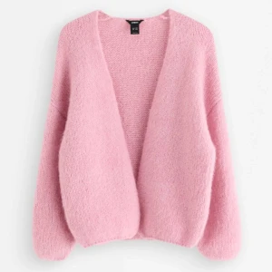 Rosa stickad kofta från Lindex - Mysig och fluffig rosa stickad kofta från Lindex i storlek M/L. Koftan har en öppen front utan knappar, långärmade ärmar och en loose passform. Perfekt för lager-på-lager och ger en chill vibe till din outfit.