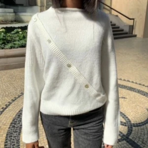 Vit stickad tröja med knappar - Snygg vit stickad tröja med lång ärm och dekorativa knappar i sned linje över framsidan. Säljer för att den inte kommer till användning. Endast använd en gång. Bara att skriva om man har nån fundering elr vill ha mer bilder 💗
