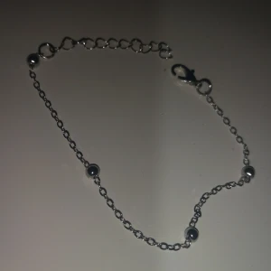 Tunt silverfärgat armband med kulor - Snyggt och minimalistiskt armband i silverfärg med små runda kulor längs den tunna kedjan. Justerbar längd med flera öglor och smidig karbinhake. Perfekt för dig som gillar stilrena detaljer och vill ha något enkelt men ändå coolt.