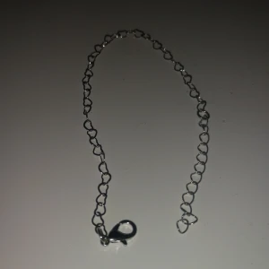 Silverfärgat armband  - Snyggt armband i silverfärg med länkar formade som små hjärtan. Kedjan är tunn och har en klassisk karbinlås som gör det enkelt att ta på och av. Perfekt för dig som gillar stilrena detaljer med en touch av romantik.