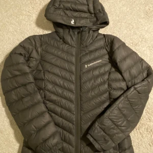 Peak Performance Jacka - Grå/grön dunjacka från Peak Performance. Säljer då den inte kommer till användning. Jag har köpt den här på plick och jackan har några mindre fläckar som knappt syns. Kom privat för fler frågor 💕