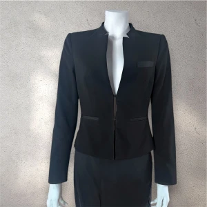 Stockh LM svart kavaj med modern krage - Stilren svart kavaj från Stockh LM med lång ärm och unik, modern krage som har ett snyggt snitt. Perfekt för dig som gillar minimalistisk och trendig stil. #stockhlm #kavaj