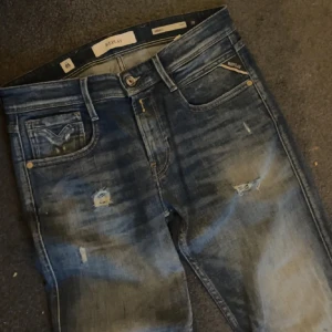 Replay anbass aged 05 - Säljer ett par feta replay anbass aged 05 med galet snygga slitningar!!! Storleken 30/32! Defekt se bild 4 , blå målarfärg men enligt mig passar bra in och gör att jeansen får en fet look!
