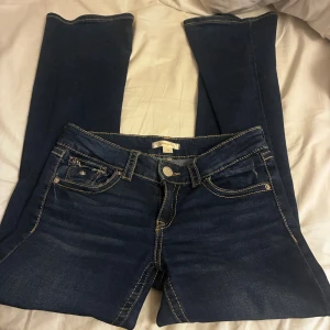 lågmidjade bootcut jeans - säljer dessa blå lågmidjade jeans med fina sömmar storlek 32-34 