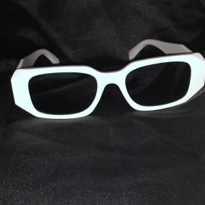 Vita solglasögon Prada - 🤍 Snygga vita Prada-glasögon till salu! 👓 En elegant och modern modell som ger en exklusiv touch till din stil. Den vita färgen gör dem unika och trendiga – perfekta både till vardags och fest ✨ Lätta, bekväma och med den ikoniska Prada-designen som aldrig går ur tiden.