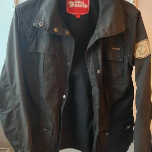 Svart Fjällräven fieldjacka  - Snygg fjällräven fieldjacket som tyvärr inte kommer till användning längre. Jackan är väldigt använd men har inga hål eller något annat, den är däremot lite sunfaded men den har väldigt mycket kvar att ge, priset är diskuterbart hör av er vid frågor!