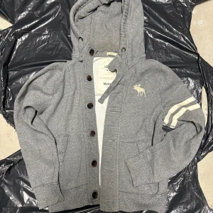 Vintage grå Abercrombie Hoodie med Knappar  - Extremt sällsynt vintage Abercrombie hoodie med knappar! Grymt skick, inga defekter och storlek M! Skriv vid frågor!💬