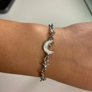 Silverfärgat armband med måne och stjärnor - Snyggt armband i silverfärg med en måne och små stjärnor som detaljer. 