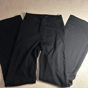 Svarta utsvänga byxor  - Svarta utsvängda byxor från 157 i storlek S. De har en enkel och clean design med elastisk midja och raka ben. Dom har slits vid slutet av benet!