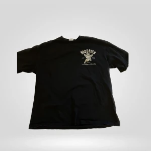 Svart t-shirt från Hoodrich XS - Svart t-shirt från Hoodrich i bomull med tryck av en ängel och texten 'Hoodrich our way' på ryggen. Framsidan har mindre tryck men samma som på ryggen. Klassisk passform och rund hals.