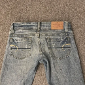 Blå bootcut jeans från American Eagle - GALET SNYGGA ljusblå jeans ifrån American Eagle. Köpta här på Plick men var tyvärr för små för mig. Midja- 36,5cm tvärsöver Grenhöjd- 17cm Innerbenslängd- 83-84cm😊