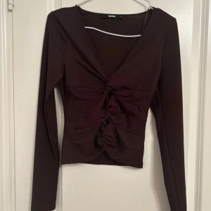 Brun ribbad topp med snörning Bikbok - Säljer en brun långärmad topp från Bikbok i storlek S. Toppen har ribbad struktur, v-ringning och snygg snörning framtill som ger en cool detalj. Materialet är mjukt och stretchigt, perfekt för dig som gillar trendiga och bekväma plagg.