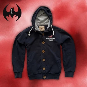 Blåsvart kofta Hollister med tryck  - Blåsvart kofta med tryck och logo på bröstet från Hollister | Size S/M | Längd: 68cm Armlängd 62cm Axelbredd: 48cm | Passar mellan från 165-178 cm